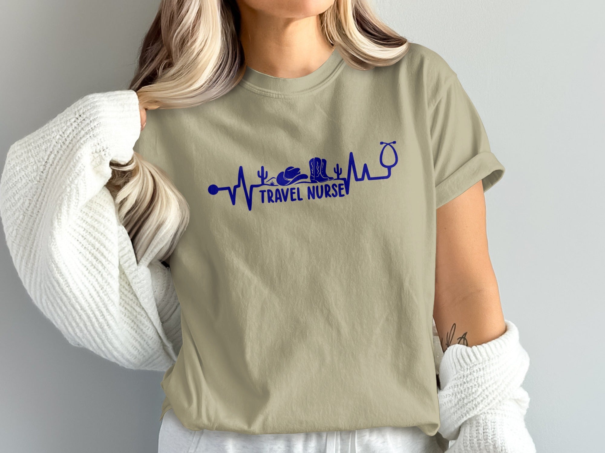 Tan t-shirt with stethoscope heartbeat design featuring cowboy hat, cactus, and "TRAVEL NURSE".