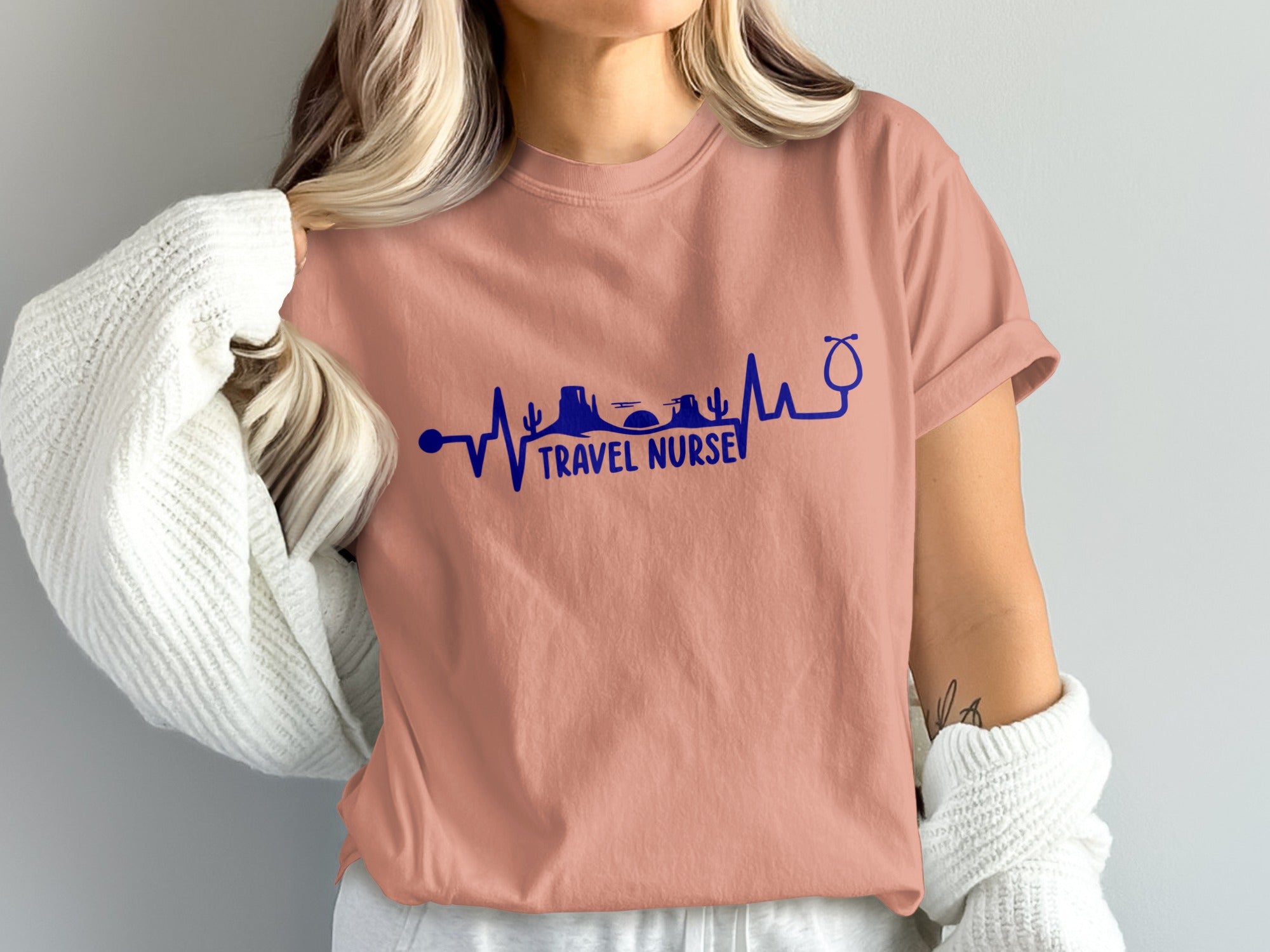 Coral t-shirt with "Travel Nurse" text and desert mountain skyline graphic.