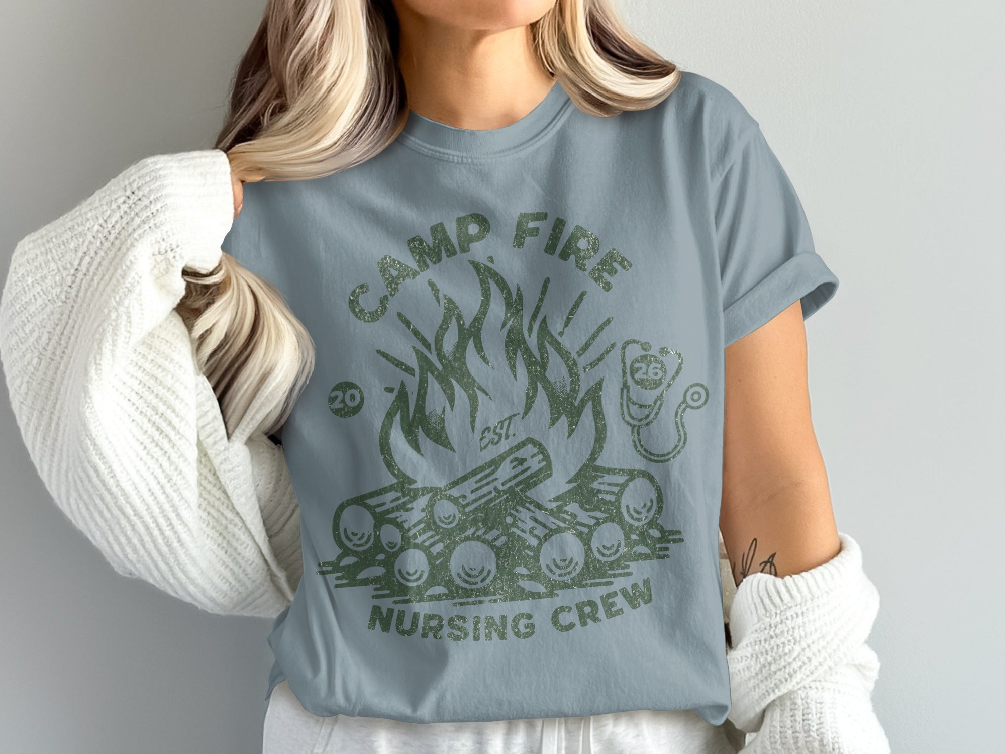 Camp fire nursing crew graphic on a light blue t-shirt.