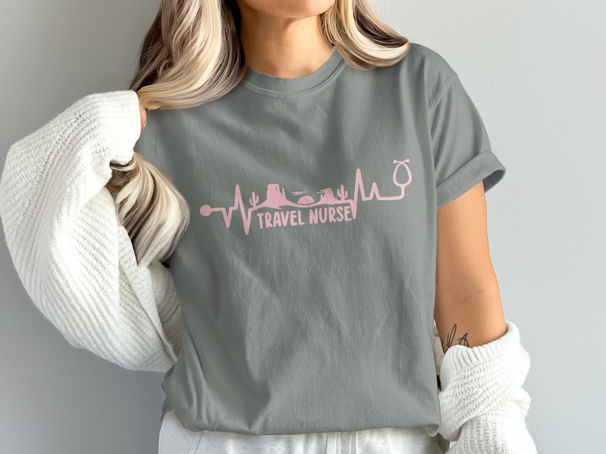 Grey t-shirt with pink heartbeat graphic and "TRAVEL NURSE" text.