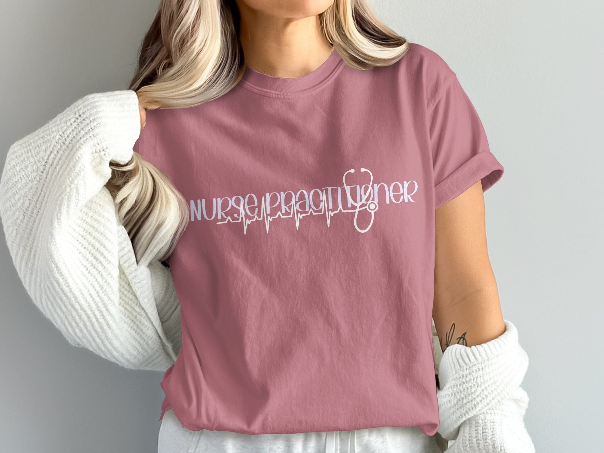 Pink t-shirt with "Nurse Practitioner" text and a stethoscope heartbeat graphic.