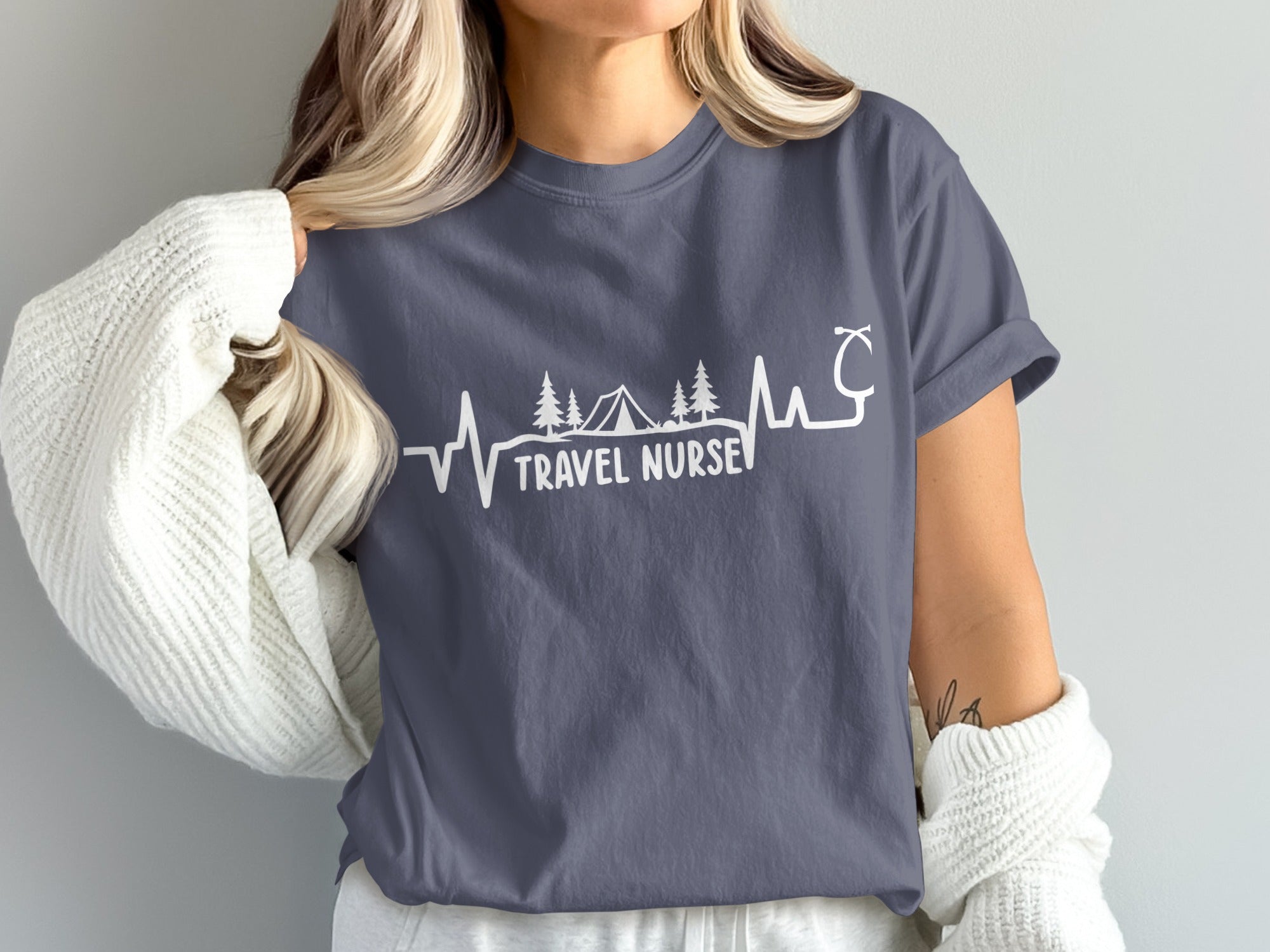 "Travel Nurse" text with a heartbeat, trees, and tent design on a gray t-shirt.