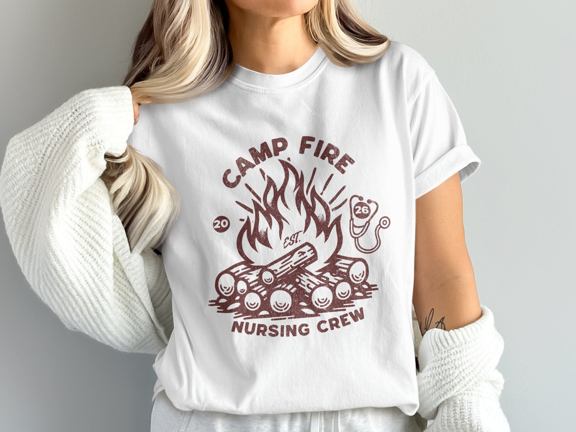 White t-shirt with campfire graphic and text "CAMP FIRE NURSING CREW EST 20".