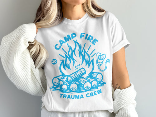 White t-shirt with blue campfire and "Trauma Crew" text.