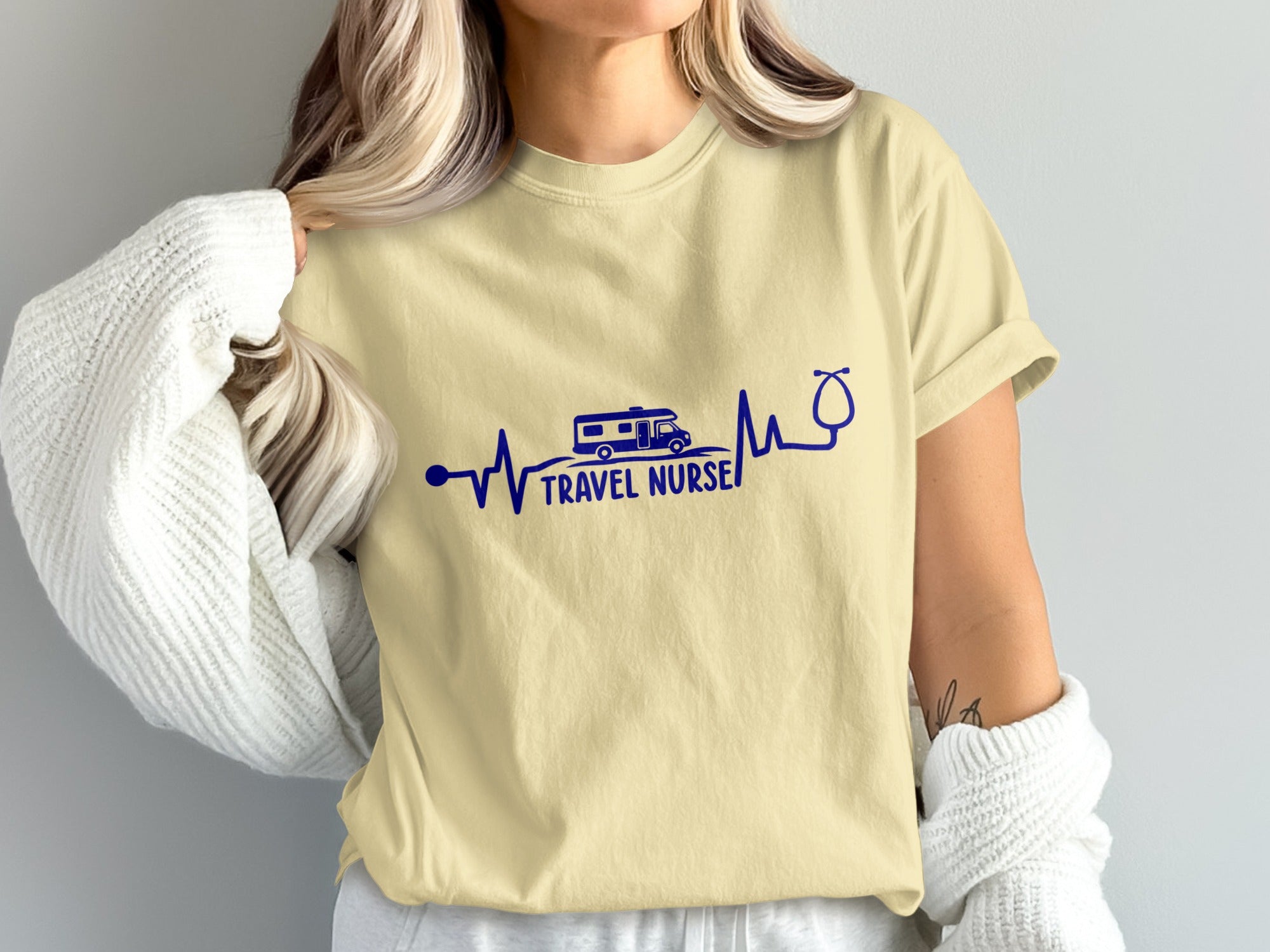 Cream t-shirt with stethoscope, RV, and "Travel Nurse" text graphic.