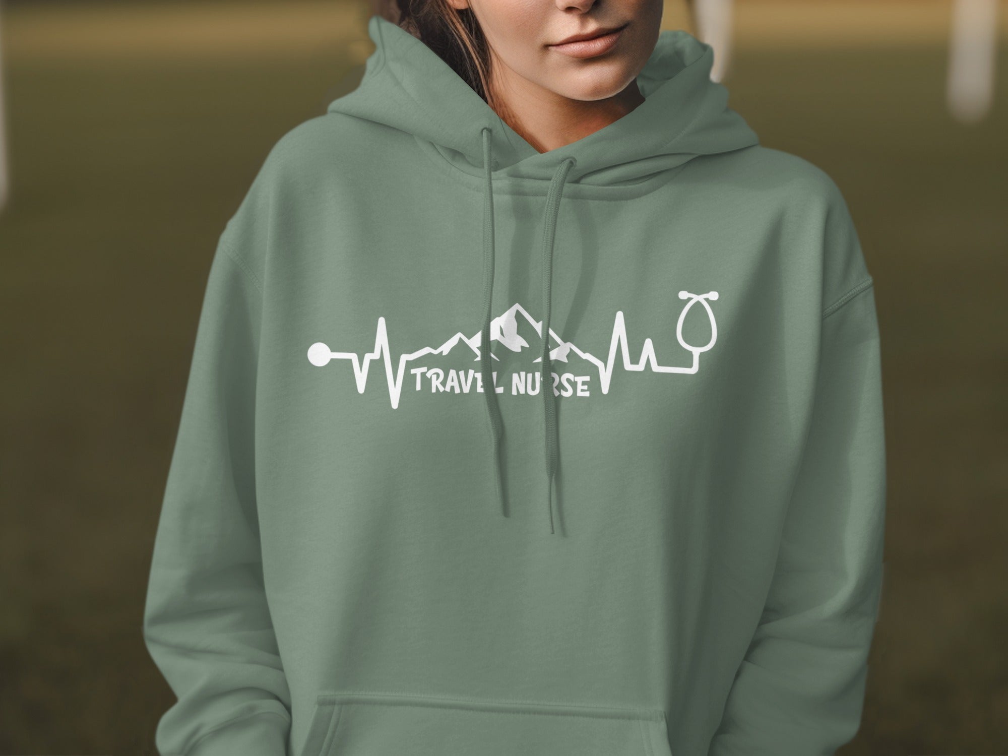 Green hoodie with "TRAVEL NURSE" and heartbeat graphic with mountains.