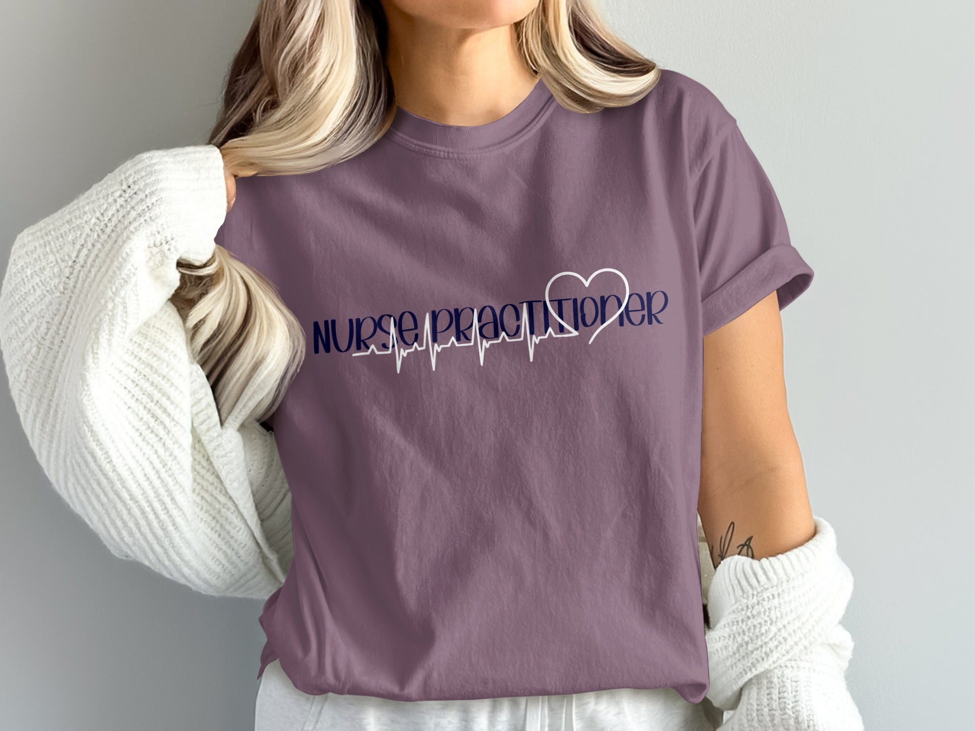Purple t-shirt with "Nurse Practitioner" and heartbeat graphic.