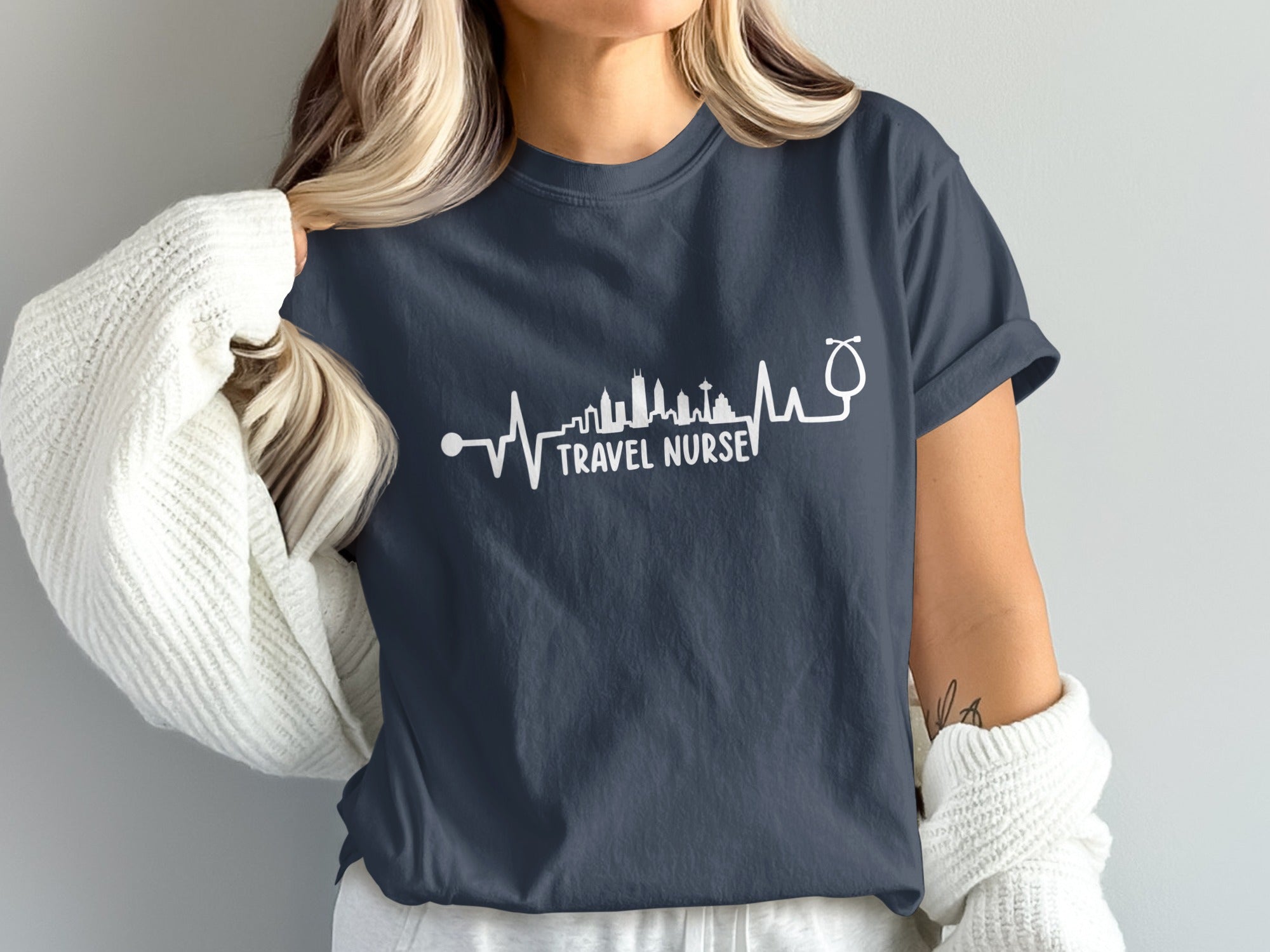 Navy t-shirt with a white stethoscope and skyline graphic and "Travel Nurse" text.