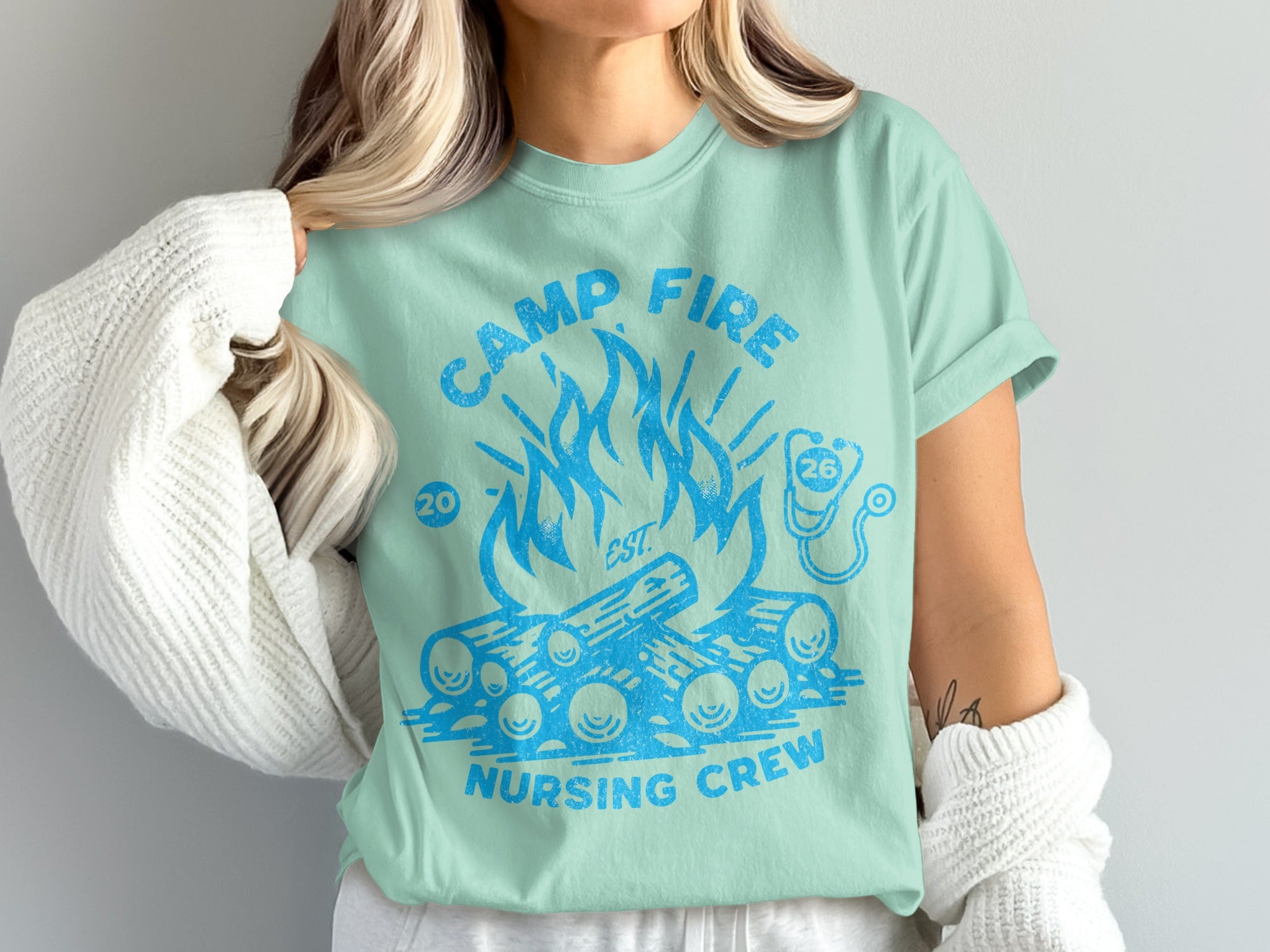 Mint t-shirt with campfire graphic and "Camp Fire Nursing Crew" text.