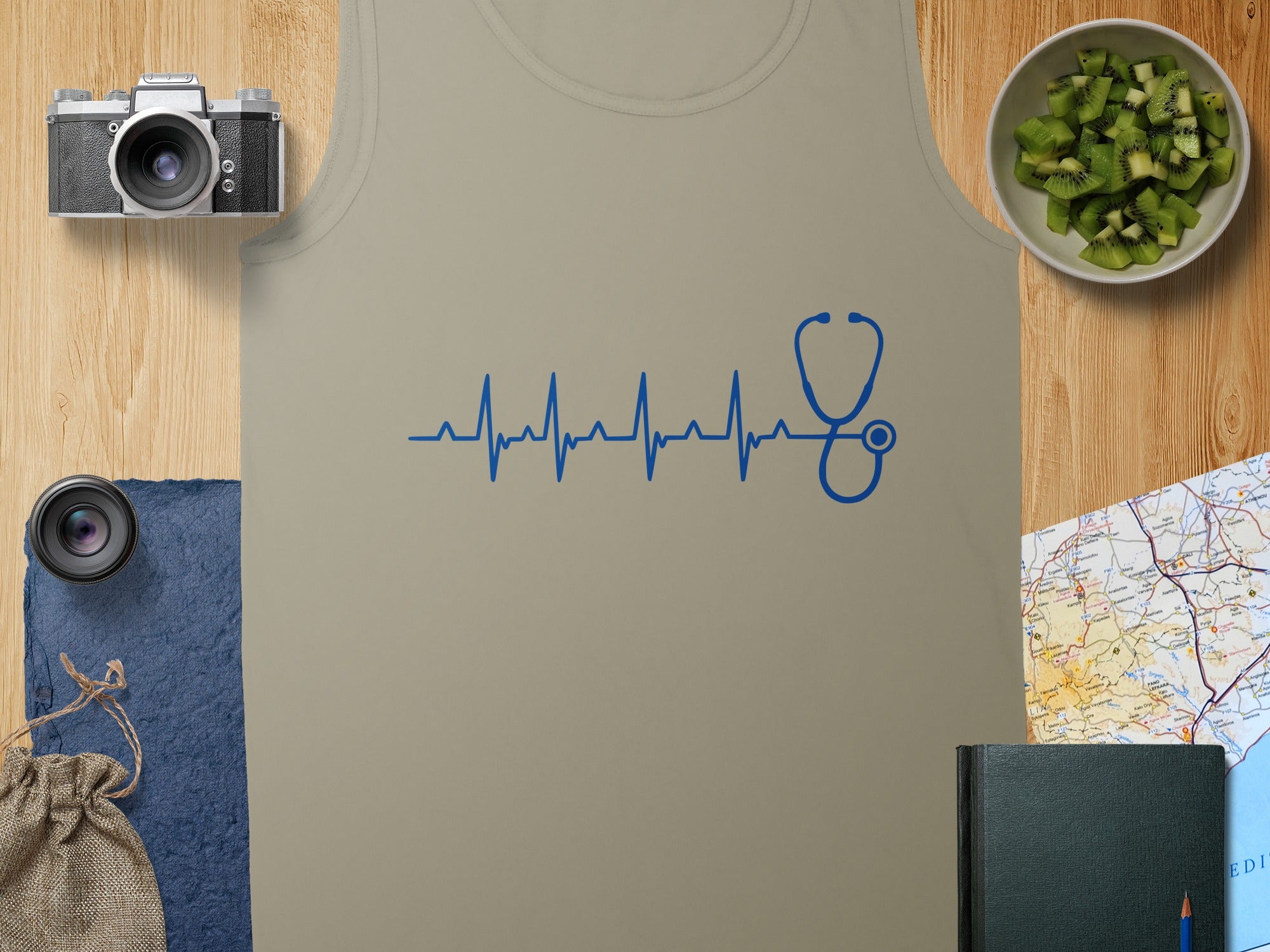 Tan tank top with blue stethoscope heartbeat graphic and kiwi slices.