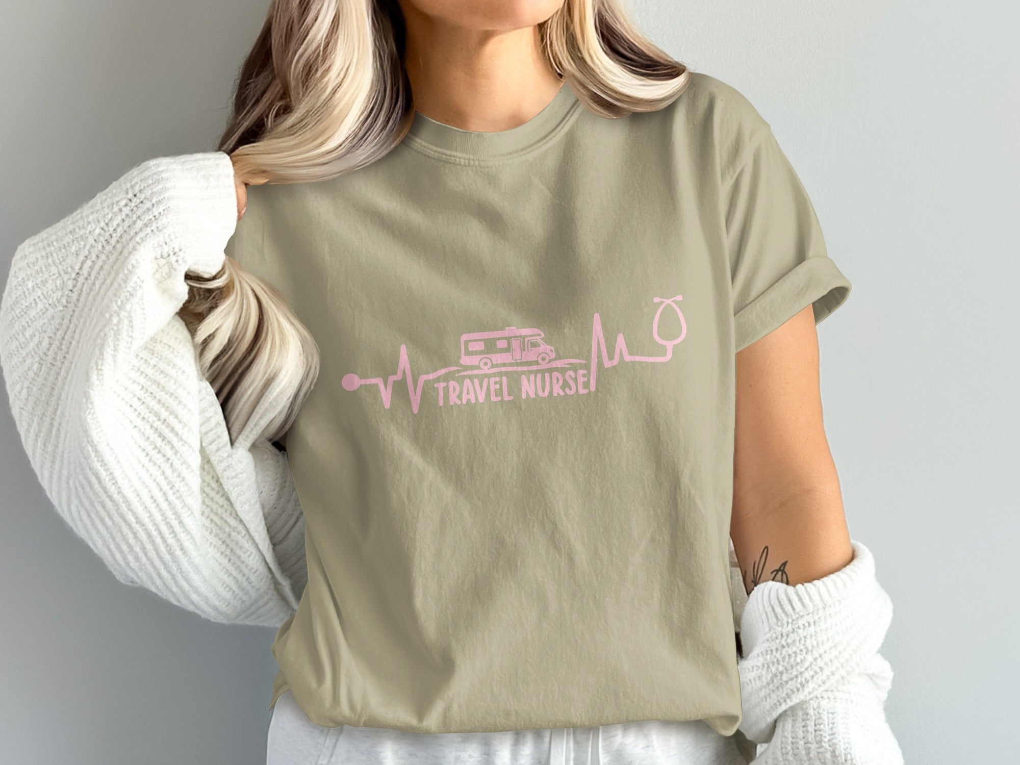 Tan t-shirt with pink heartbeat, RV, and stethoscope graphic and "Travel Nurse" text.