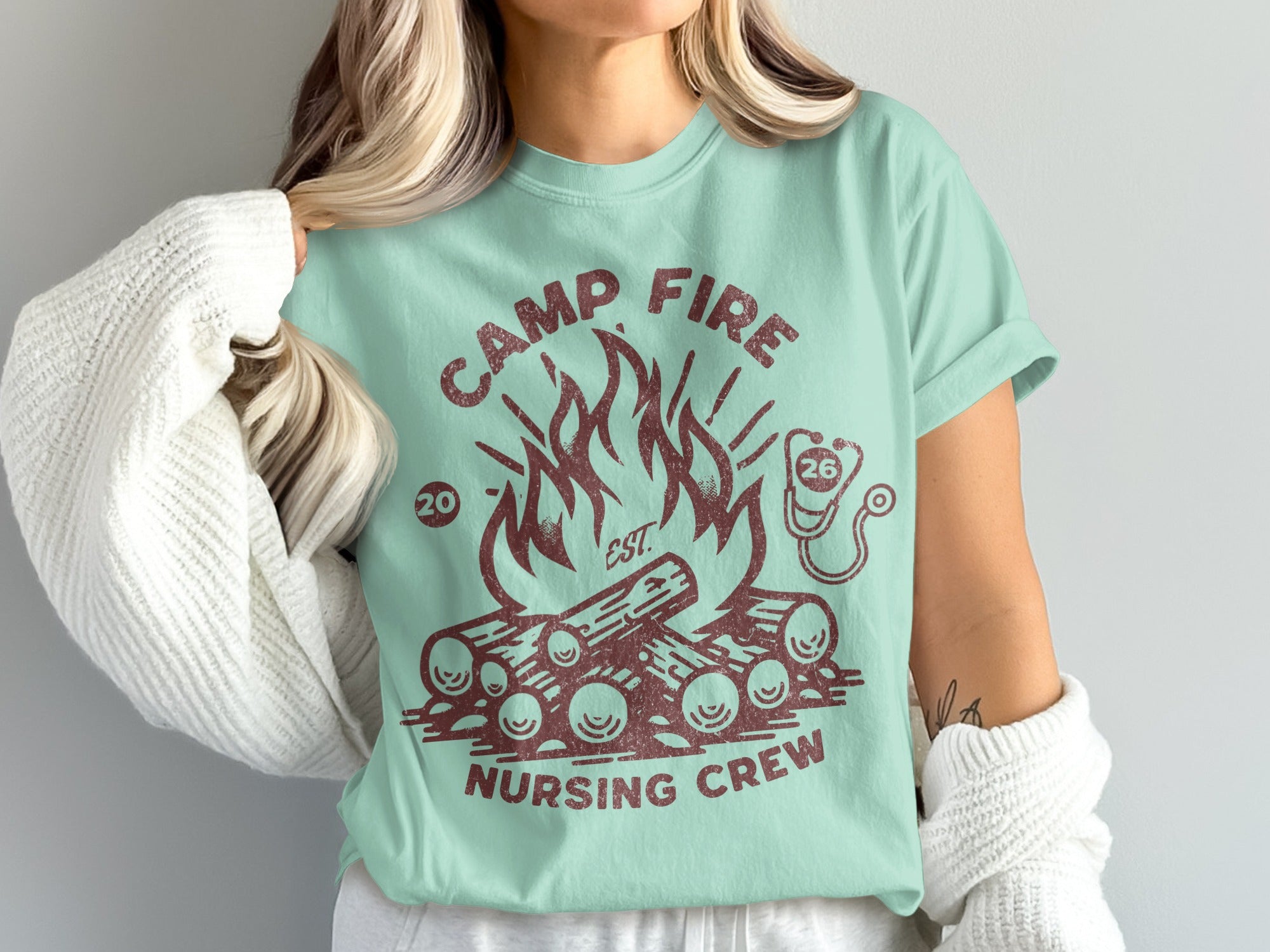 Teal t-shirt with "Camp Fire Nursing Crew" text and campfire graphic.