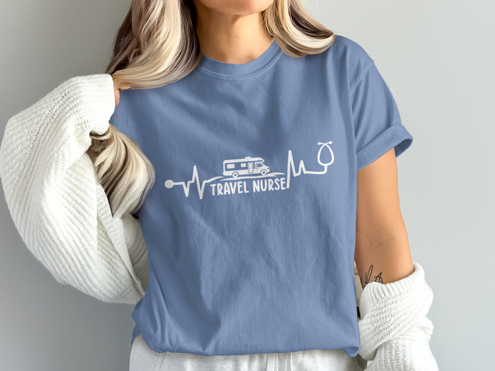 Blue t-shirt with white heartbeat graphic showing a camper van and stethoscope.