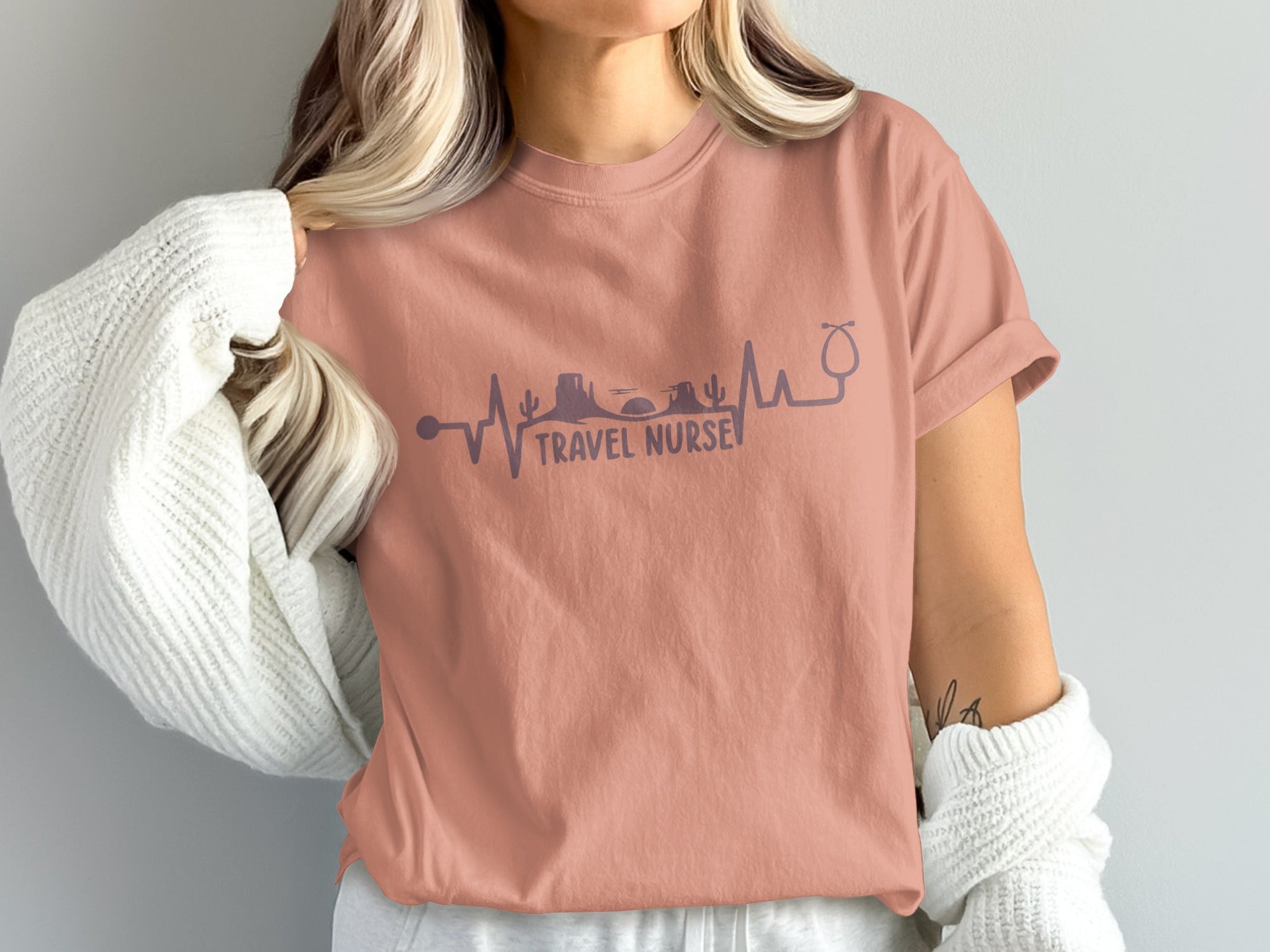 Coral t-shirt with travel-themed heartbeat graphic and stethoscope.