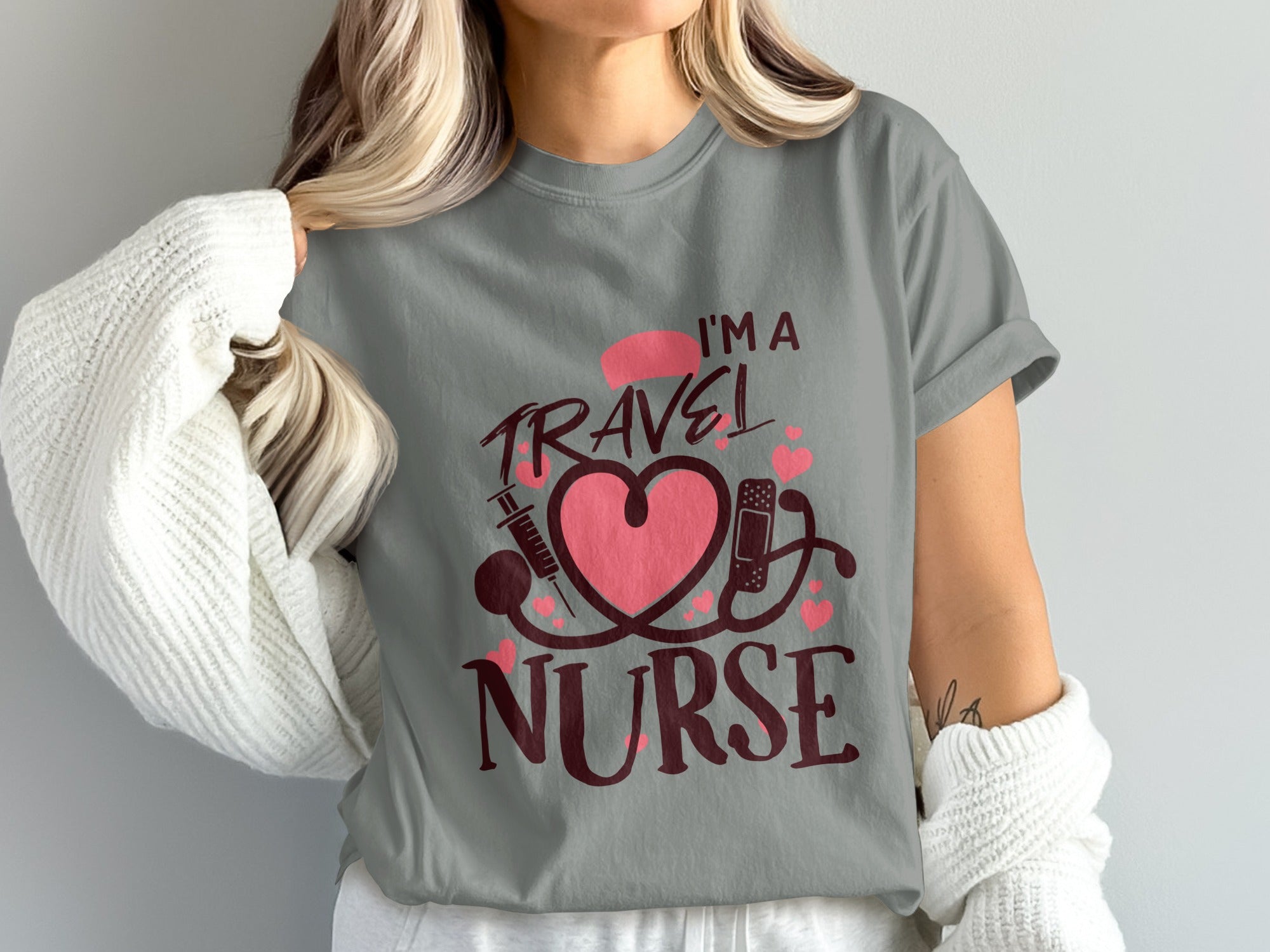 Gray t-shirt with pink stethoscope, heart, and syringe graphic and "I'm a Travel Nurse" text.