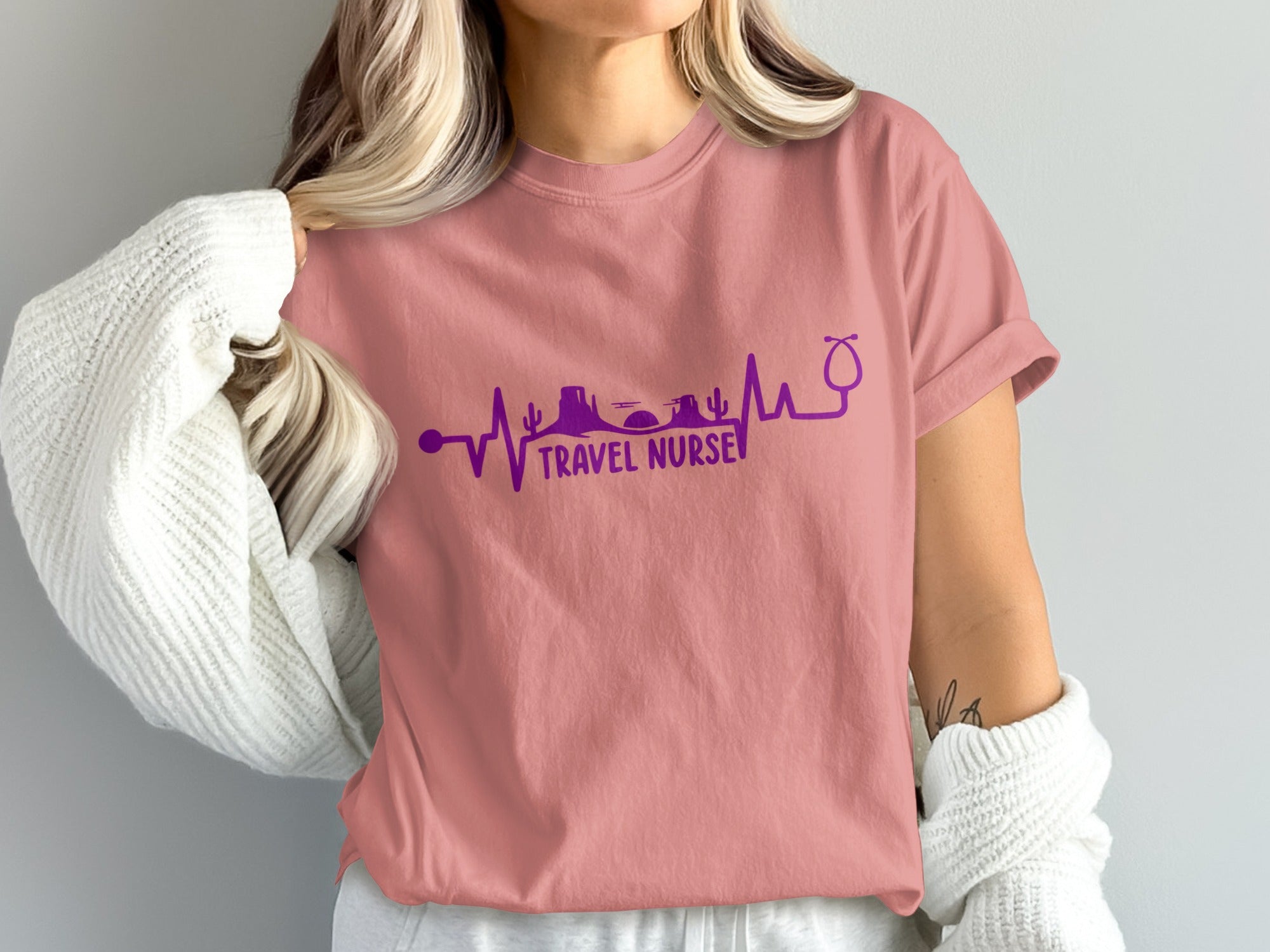 Pink t-shirt with "Travel Nurse" text, desert landscape, and stethoscope design.