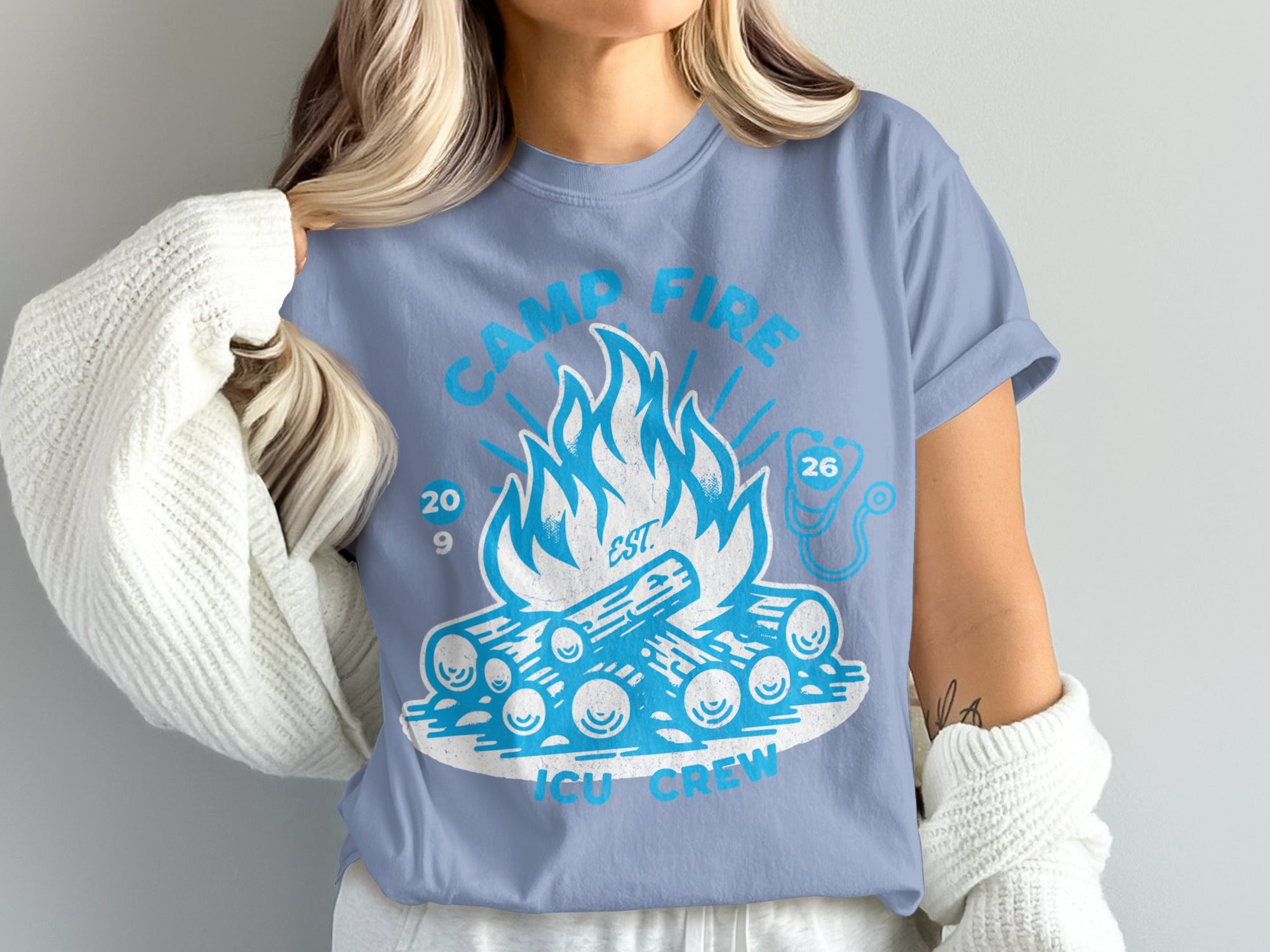 Blue t-shirt with campfire graphic and text "CAMP FIRE 20 26 ICU CREW".
