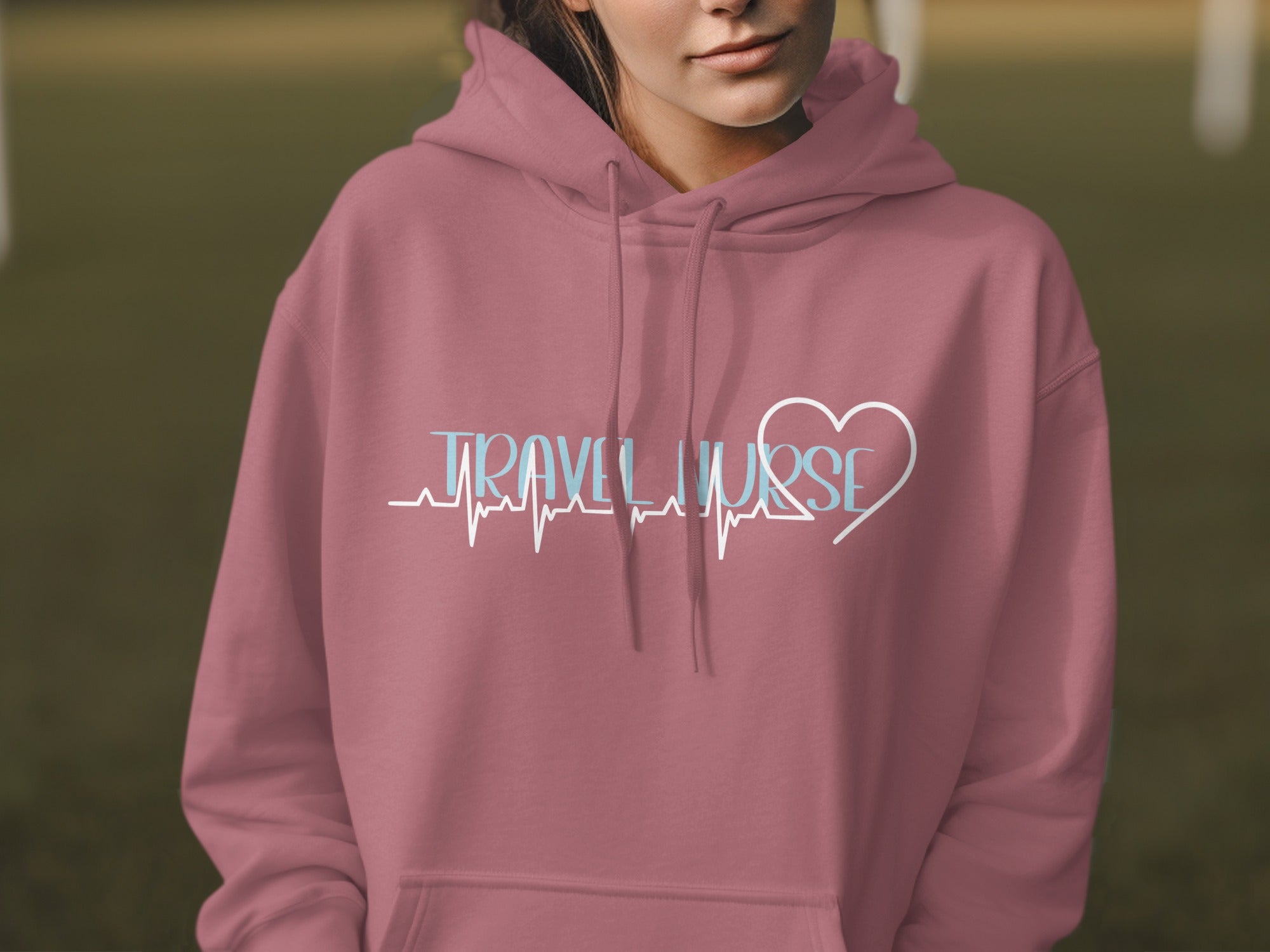Rose pink hoodie with "TRAVEL NURSE" text and heart heartbeat graphic.