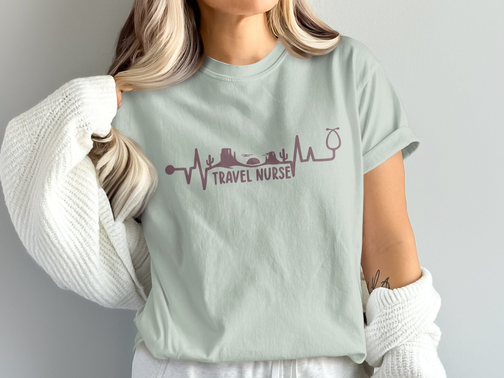 Light sage t-shirt with travel nurse heartbeat graphic and stethoscope.