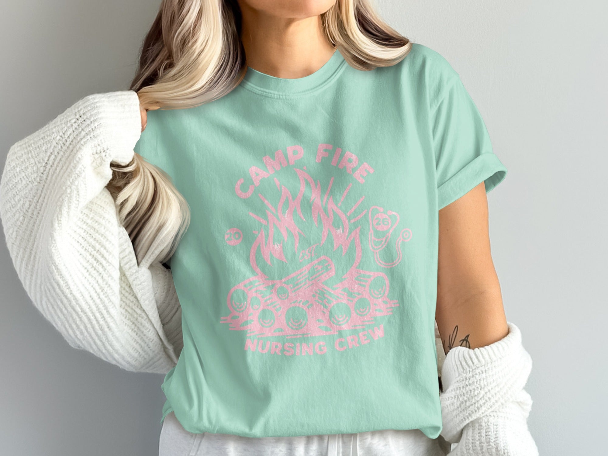 Mint green t-shirt with pink campfire and "Camp Fire Nursing Crew" text.