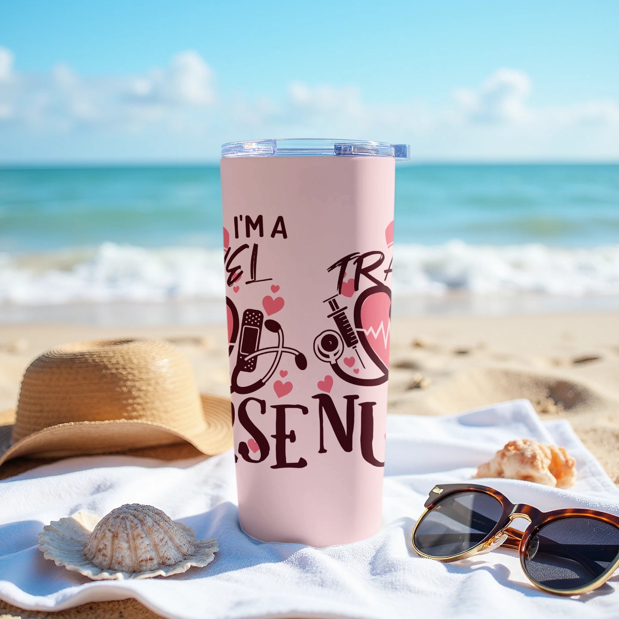 Pink tumbler with "I'm a nurse" and medical icons, on a beach towel.