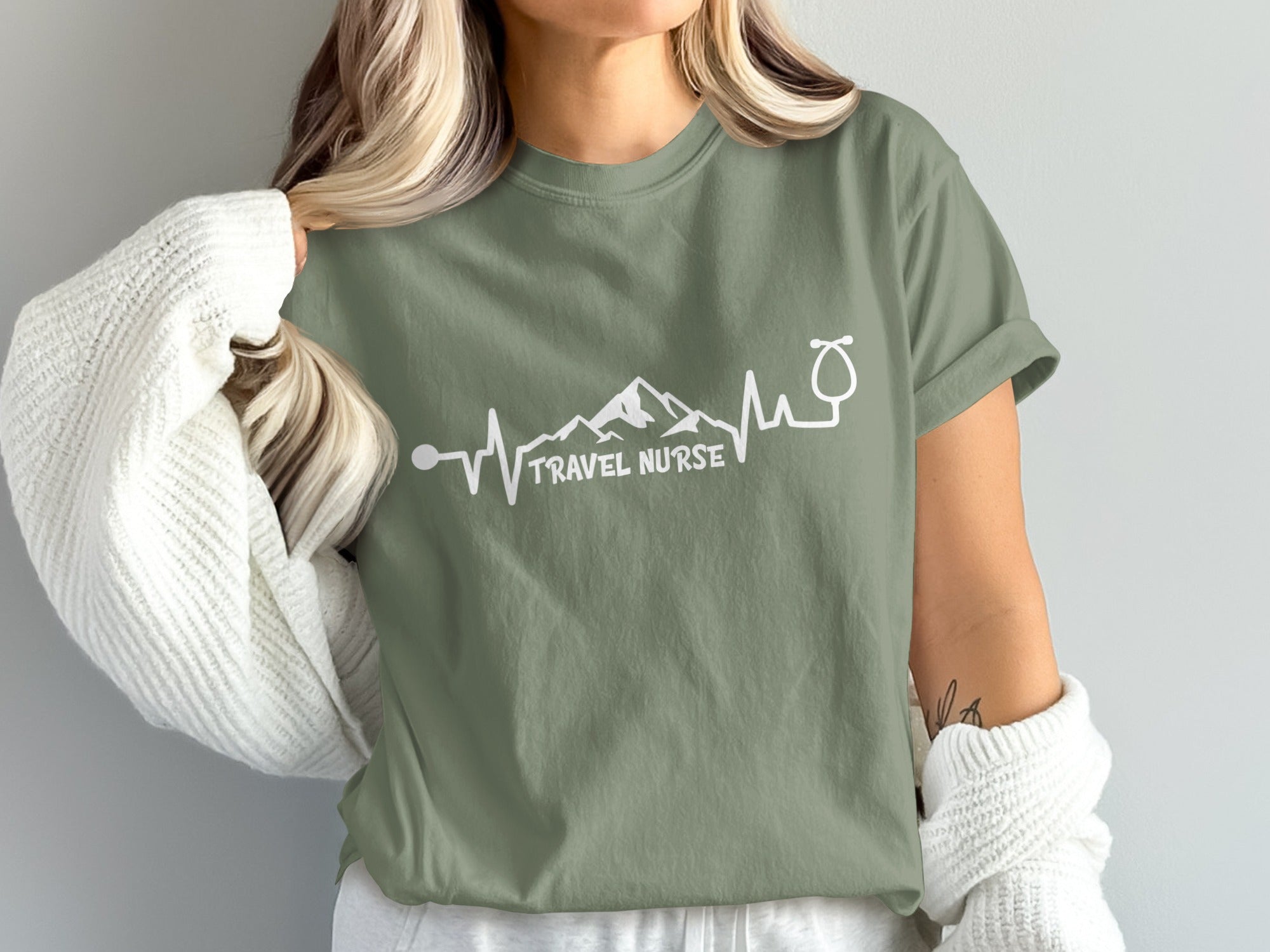 Green t-shirt with "Travel Nurse" text and mountain/stethoscope heartbeat graphic.