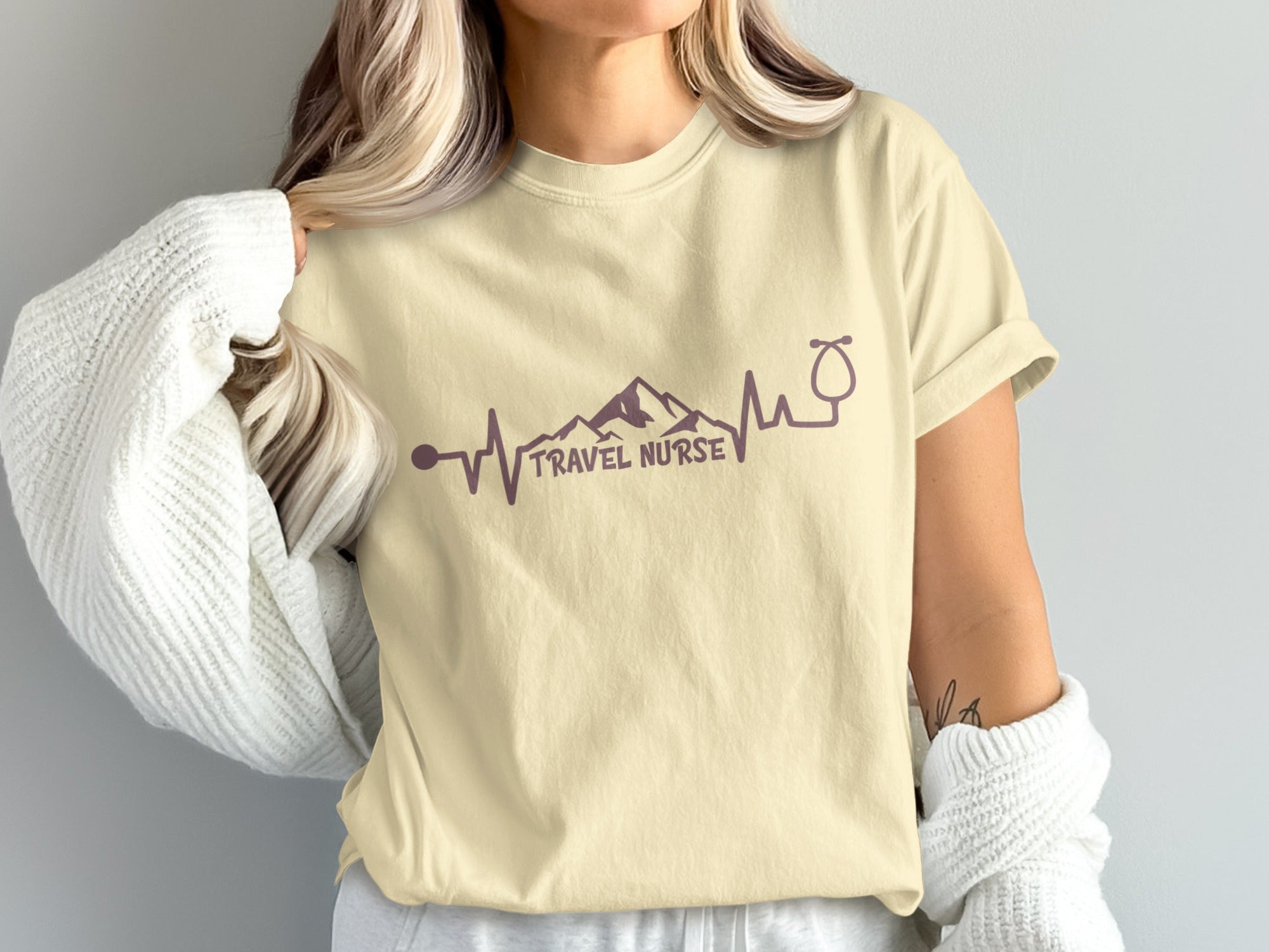 Cream t-shirt with purple "Travel Nurse" text and heartbeat graphic.